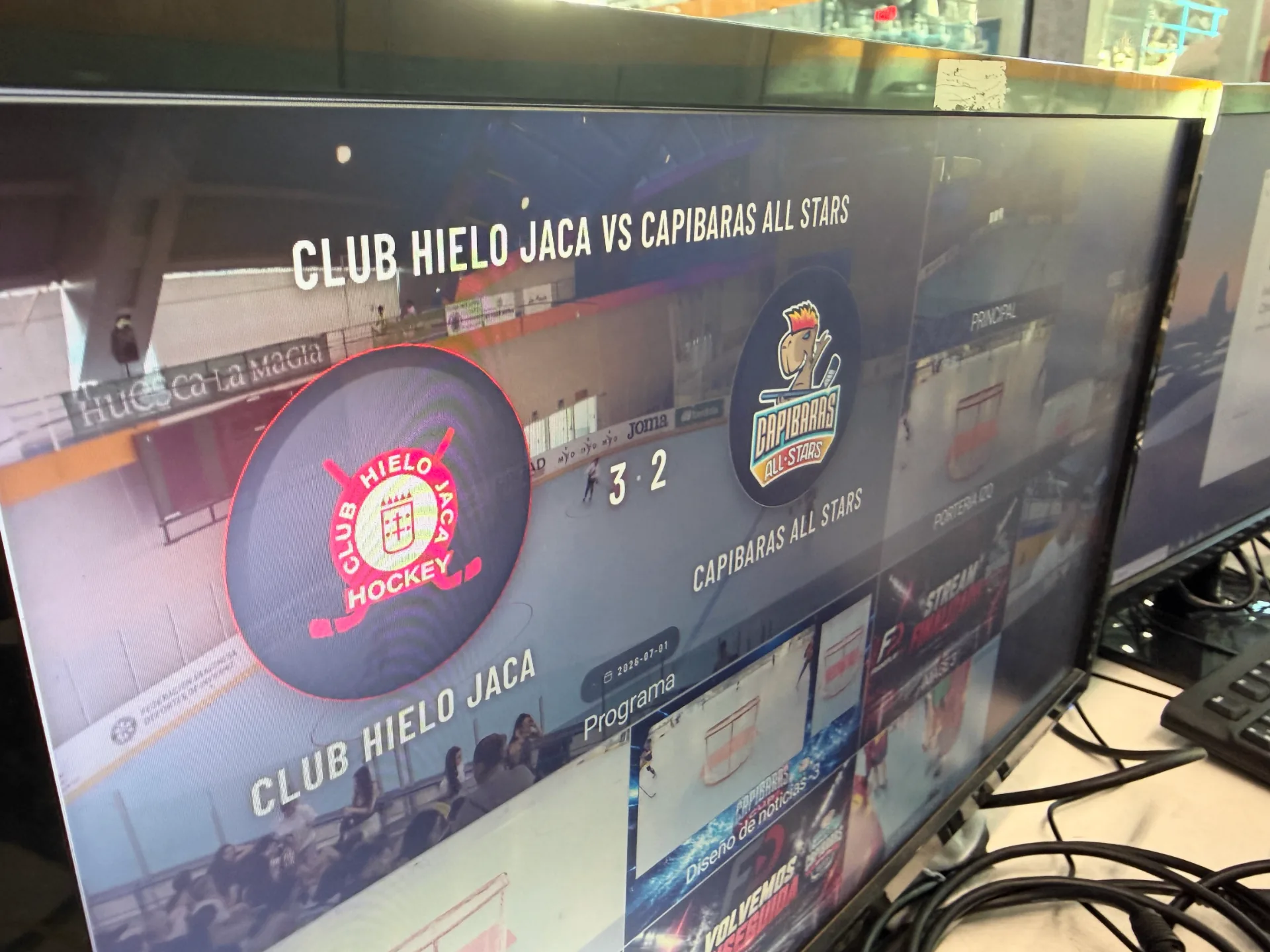 Multiview de realización en directo durante la Capibaras Cup, con el marcador entre Club Hielo Jaca y Capibaras All Stars, cámaras de portería y placas de marcador